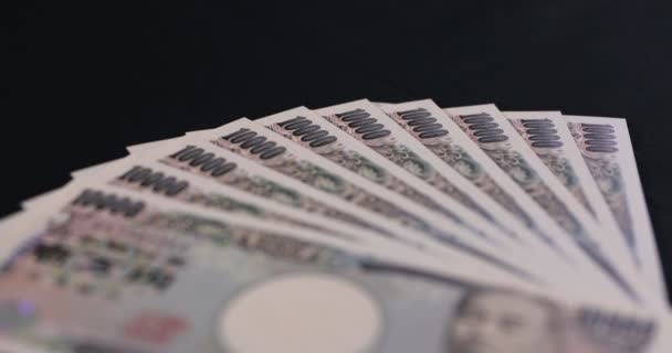 Ιαπωνικό νόμισμα 100.000 γιεν στο μαύρο φόντο κλίση — Αρχείο Βίντεο