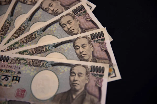 Japanische Währung 100.000 Yen auf schwarzem Hintergrund Nahaufnahme — Stockfoto