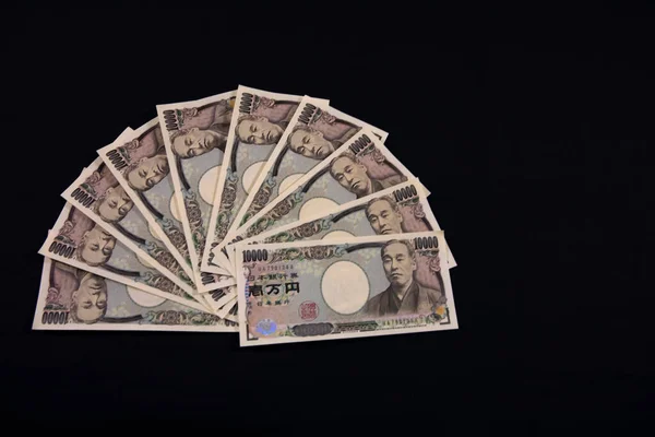 Moeda japonesa 100.000 ienes sobre o fundo preto copyspace — Fotografia de Stock