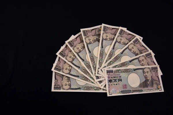 Moeda japonesa 100.000 ienes sobre o fundo preto copyspace — Fotografia de Stock