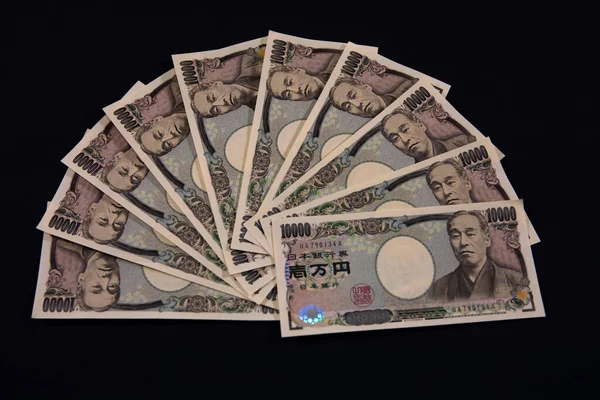 Moneda japonesa 100.000 yen en el primer plano de fondo negro —  Fotos de Stock