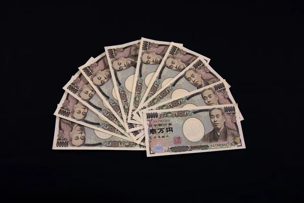 Японская валюта 100000 иен на черном фоне крупным планом — стоковое фото