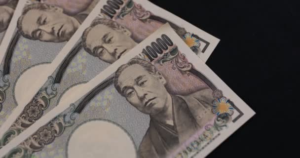Японська валюта 100 000 ієн на чорному тлі — стокове відео