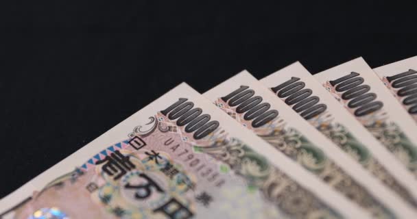 Japanse valuta 100.000 yen op de zwarte achtergrond panning — Stockvideo