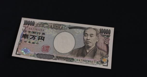 Contando la valuta giapponese 100.000 yen a mano sullo sfondo nero — Video Stock