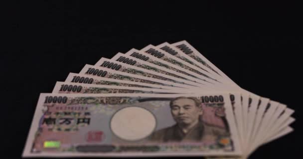 Japansk valuta 100.000 yen på svart bakgrund lutning — Stockvideo