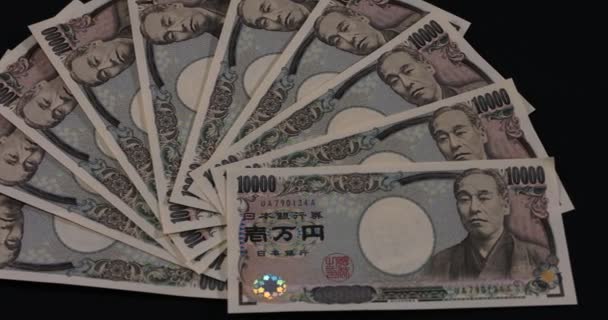 Valuta giapponese 100.000 yen sullo sfondo nero panning — Video Stock