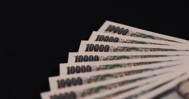 Японская валюта 100.000 иен на черном фоне — стоковое видео