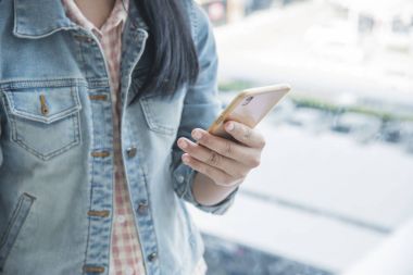 Genç alışveriş merkezinde cep telefonu kullanan kadın