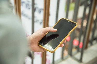 Erkek el bir telefon bir alışveriş merkezi üzerinde tutarak