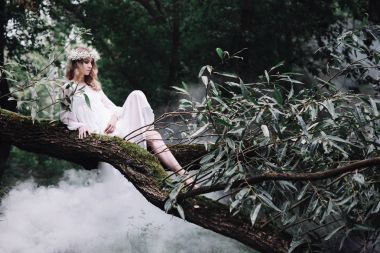 Karanlık bir ormanda beyaz elbiseli güzel kız.