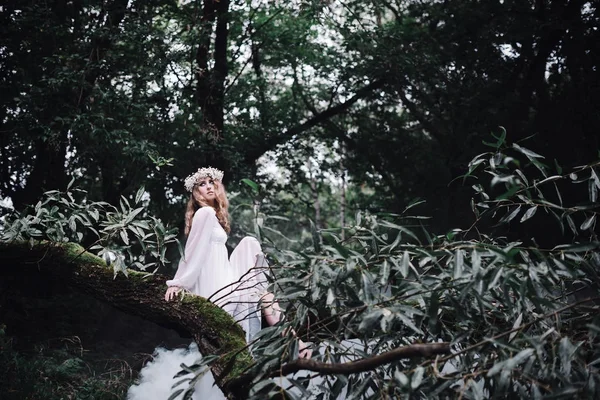 Menina bonita em um vestido branco em uma floresta escura . — Fotografia de Stock