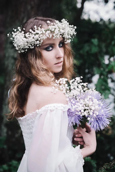 Karanlık bir ormanda beyaz elbiseli güzel kız.