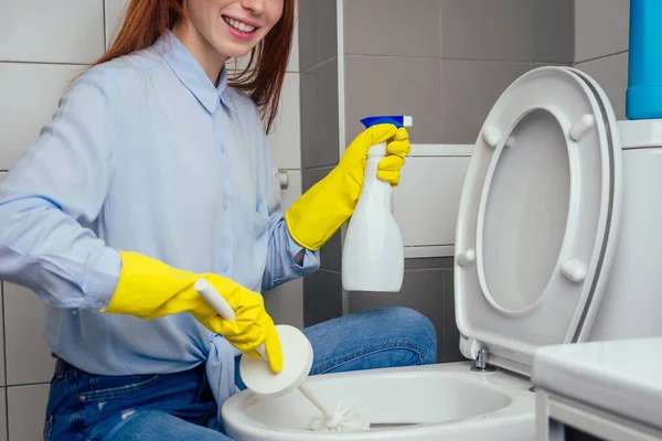 Cheereful redhaired ginger woman washing in rest room toilet wearing gloves — Stock Photo, Image