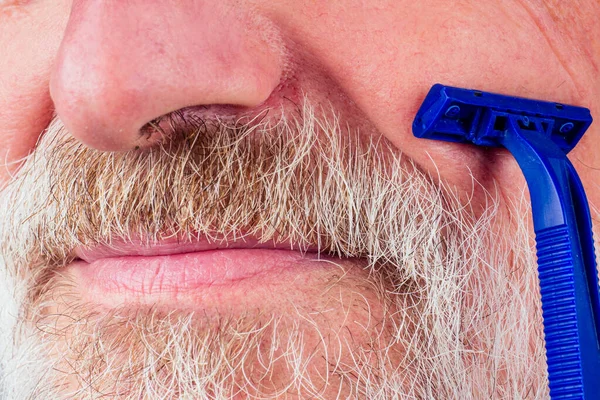 Homem velho barbeador barba de cabelos grisalhos azul navalha descartável em estúdio fundo branco — Fotografia de Stock