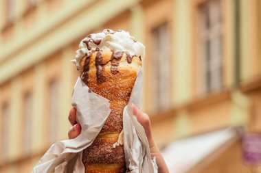 Prag caddesinde vanilya kremalı ve çilekli geleneksel Çek tatlısı Trdelnik 'i iştah yer.