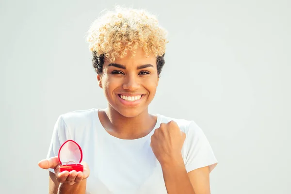 Heureuse femme brésilienne latine faire une proposition avec bague en or à boîte rouge sur fond de studio blanc — Photo