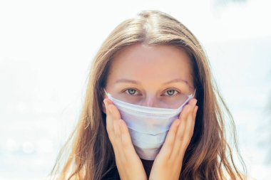 Tropik plajda maske takan bir kadın. Korona virüsünü önleme kavramı