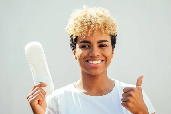 Mixte race hispanique brésilien fille tenant tampon d'hygiène en studio fond blanc et blanc neige sourire — Photo