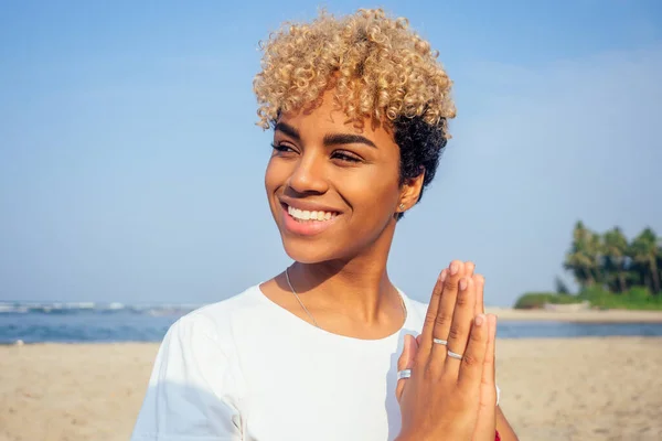 Ritratto di una giovane donna africana latina seduta in posa yoga allo stile di vita da spiaggia — Foto Stock