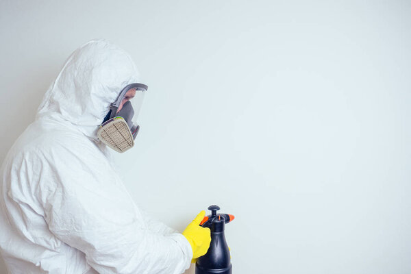 вредитель работник распыления пестицидов с распылителем в квартире копия спаз белые стены фон
