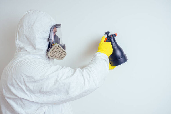 pest control worker spraying pesticides with sprayer in apartment copy spase white walls background