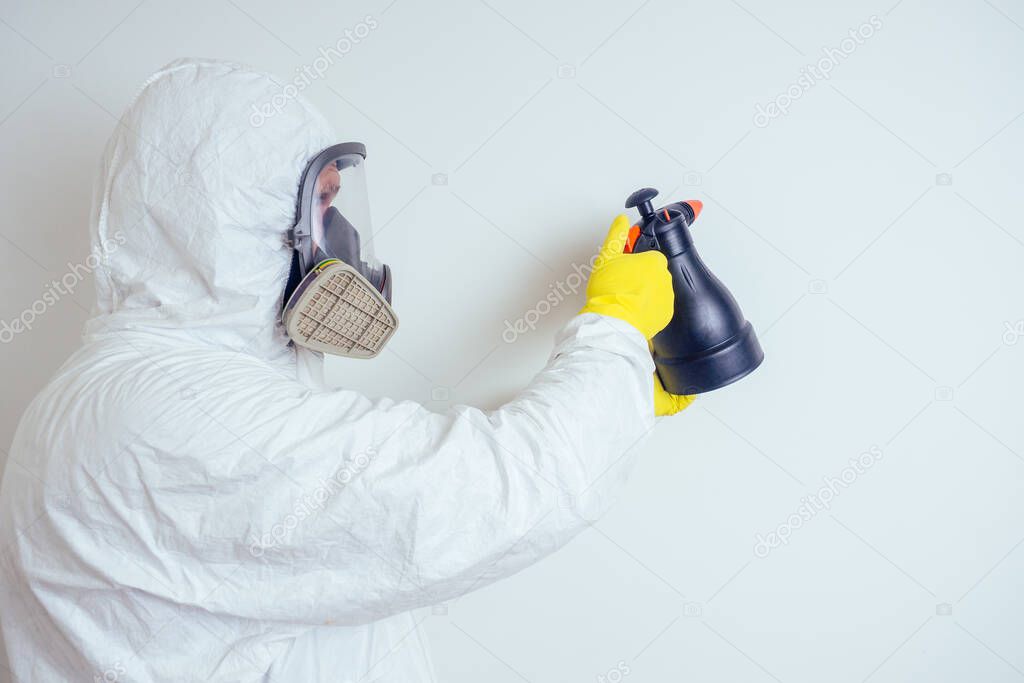pest control worker spraying pesticides with sprayer in apartment copy spase white walls background