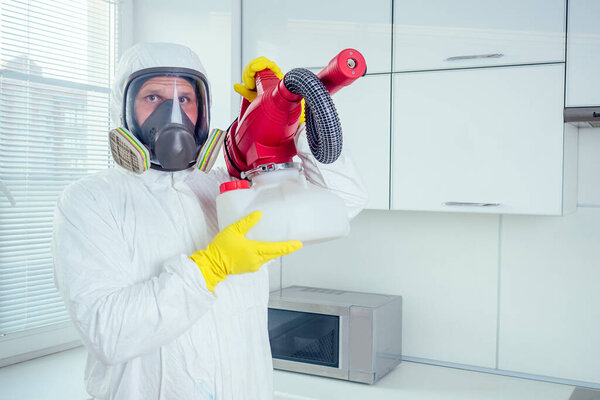 white worker spraying pesticide on induction hob