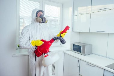 Beyaz İşçi indüksiyon hob üzerine böcek ilacı sıkıyor.