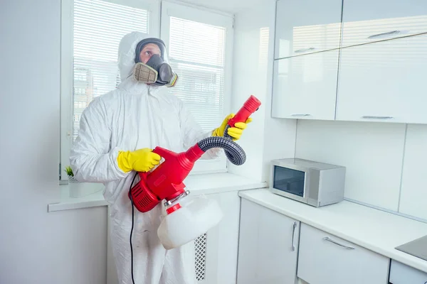 Trabalhador branco pulverizando pesticida na placa de indução — Fotografia de Stock