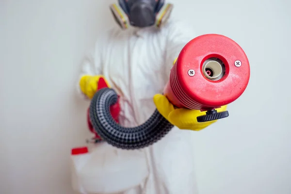 Pest control worker spraying pesticides with sprayer in apartment copy spase white walls background — 스톡 사진