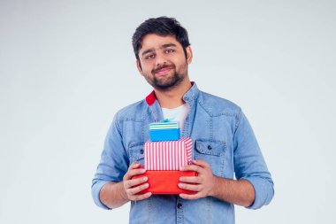 Yakışıklı hindi adam stüdyo beyaz arka planda hediye kutuları veriyor. Yeni yıl ya da Ekadashi konsepti.