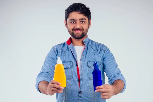 Indián muž drží láhev opalovací krém ve studiu bílé pozadí — Stock fotografie