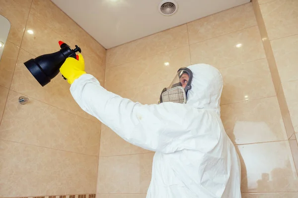 Disinfestatore spruzzando pesticidi con spruzzatore in bagno: lavorazione della toilette e della doccia — Foto Stock