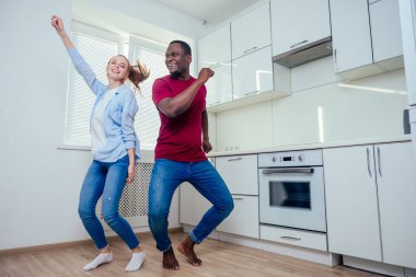 Afrikalı Amerikalı bir adam ve kızıl saçlı bir kadın Kichen 'de dans ediyor ve keyfi yerinde. Karışık ırktan yeni evliler.