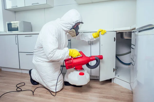 Λευκός εργαζόμενος ψεκάζει φυτοφάρμακο σε επαγωγικές εστίες — Φωτογραφία Αρχείου