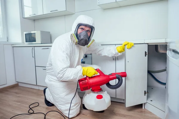 Trabalhador branco pulverizando pesticida na placa de indução — Fotografia de Stock