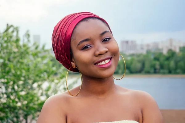 Lächelnde Afroamerikanerin mit USA-Flagge und Blick in die Kamera Herbstabend Frühling im Park am See — Stockfoto