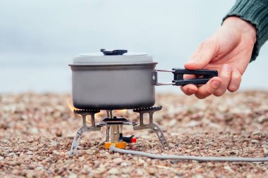 Yulaf lapalı tava gaz ocağının üstünde duruyor. Nehrin arka planında