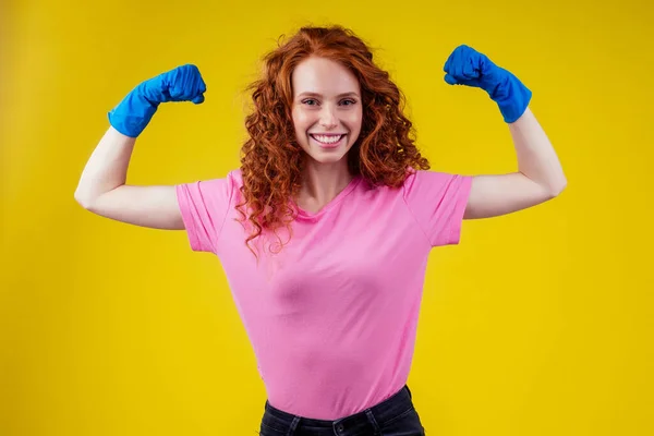 Vörös hajú göndör gyömbér nő bemutató képzési kéz izmok stúdió sárga háttér fal — Stock Fotó