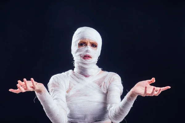 Mulher de múmia glamourosa com ligaduras por todo o corpo em estúdio fundo preto. Halloween festa ou cirurgia plástica vítima conceito — Fotografia de Stock