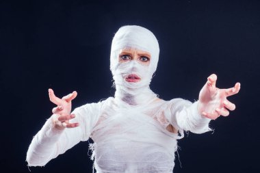 Vücudunun her yerinde bandajlı, göz kamaştırıcı mumya kadın stüdyosunun siyah arka planı