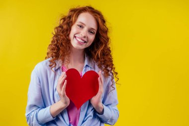 Kardiyolog kızıl bukleli mutlu kadın stüdyo sarı arka planda duyuldu.