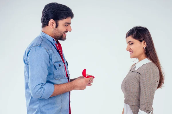 bold indian man asking her girlfriend to get wedding studio white background
