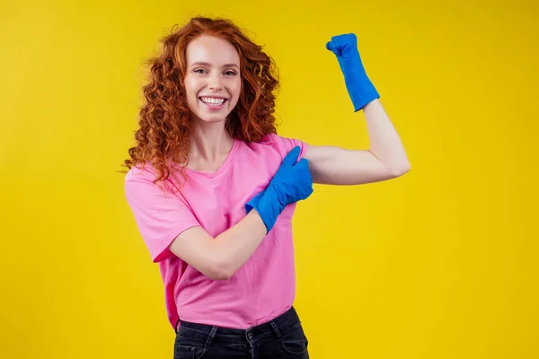 Vörös hajú göndör gyömbér nő bemutató képzési kéz izmok stúdió sárga háttér fal — Stock Fotó
