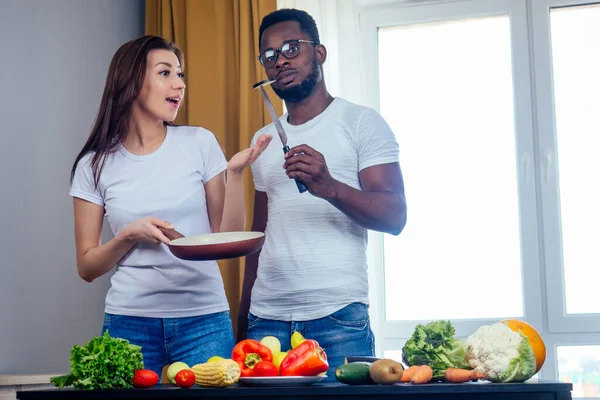 Mujer coreana wearimg camiseta de algodón blanco con su novio afroamericano cocinando en pan frito bresksast — Foto de Stock