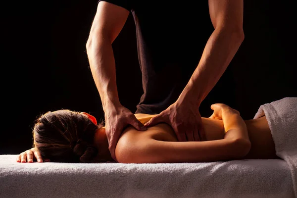 Masseur ręce robi masaż pleców do klienta w centrum spa w ciemnym pokoju — Zdjęcie stockowe