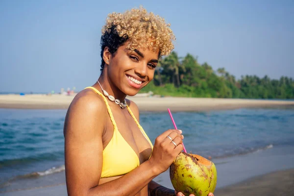 Hispanic latin beautiful female drinking coco nut water seashells on the neck — Stock Photo, Image