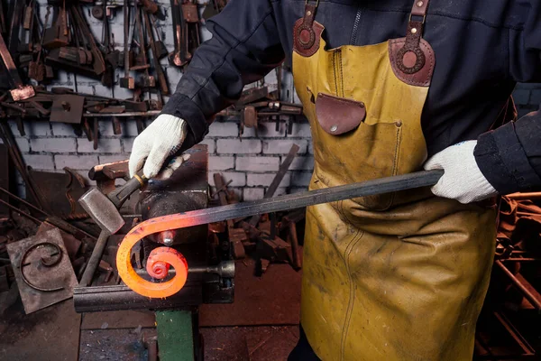 Knappe Afrikaanse amerikaanse smid mannelijke werknemer werken in de werkplaats, het dragen van lederen schort — Stockfoto