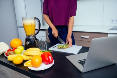 Meyve suyu barında çalışan Latin bir kadın muz, portakal ve kavundan taze meyve suyu karıştırıcı yapıyor. Yeniden kullanılabilir eko metal tüpler ve cam kullanıyor.